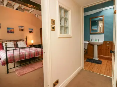 a bedroom with a bed and a sink at Gardeners Cottage in Millom