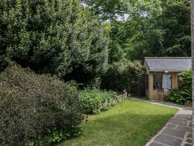 a small shed in a garden next to a yard at Gardeners Cottage in Millom