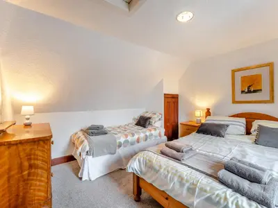 a bedroom with two beds and a desk with lamps at Carraig Dhubh North - Uk47125 in Whiting Bay