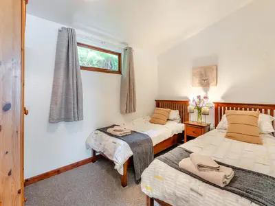 a bedroom with two beds and a window at Carraig Dhubh North - Uk47125 in Whiting Bay