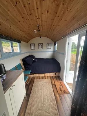a bedroom with a bed in a tiny house at Wee Shepherds Hut Maybole in Maybole