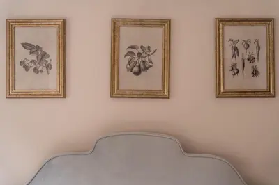 two framed drawings on a white wall with a chair at Oakbank-Central Grasmere in Grasmere