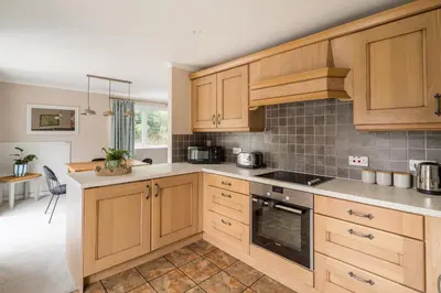 a kitchen with wooden cabinets and a stove top oven at Oakbank-Central Grasmere in Grasmere