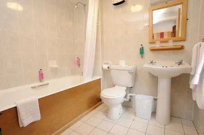 a bathroom with a toilet and a sink and a tub at Patterdale Hotel in Patterdale