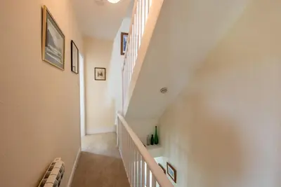 a staircase in a home with white walls at Myrtle Cottage in Chapel Stile