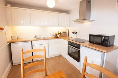 a kitchen with white cabinets and a microwave at Myrtle Cottage in Chapel Stile