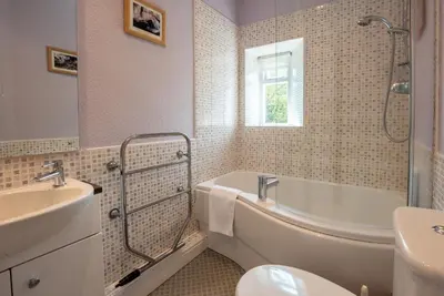 a bathroom with a tub and a sink and a toilet at Myrtle Cottage in Chapel Stile