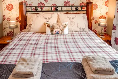 a bedroom with a bed with a dog on it at Courtyard Cottages Rose Cottage in Wigtown