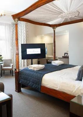 a bedroom with a large bed with a canopy at Crown & Mitre Hotel in Carlisle