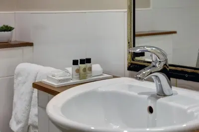 a bathroom with a white sink and a mirror at Crown & Mitre Hotel in Carlisle