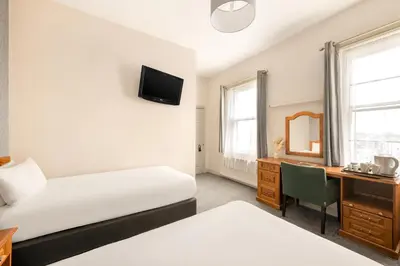 a bedroom with a bed and a desk with a mirror at The County Hotel in Carlisle