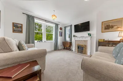 a living room with two couches and a fireplace at The Hytte, 19 Greta Grove House in Keswick
