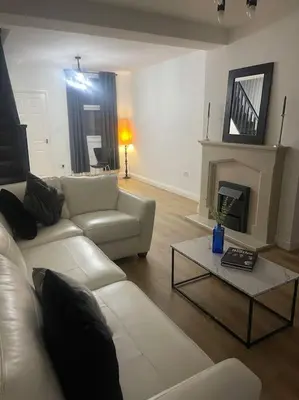 a living room with a white couch and a fireplace at Birks road in Cleator Moor