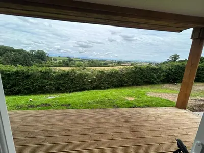 an open porch with a view of a field at Castle Glen Lodge in Dumfries