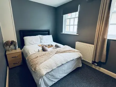 a bedroom with a bed with a teddy bear on it at Queens Townhouse - 4 Bedrooms - Sleeps 9 in Whitehaven
