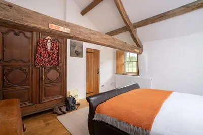 a bedroom with a bed and a wooden cabinet at Panoramic Views & Spacious Living by LetMeStay in Grasmere