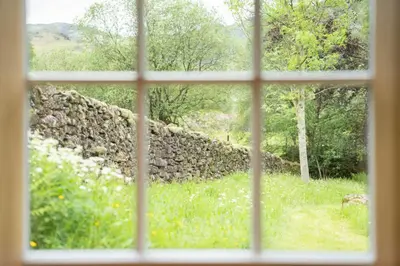 a view of a stone wall from a window at Panoramic Views & Spacious Living by LetMeStay in Grasmere