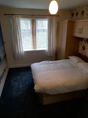 a bedroom with a large bed and a window at Smriti's in Dumfries