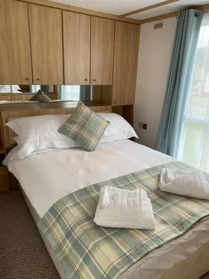 a bed with two towels sitting on top of it at Rosie in Whithorn
