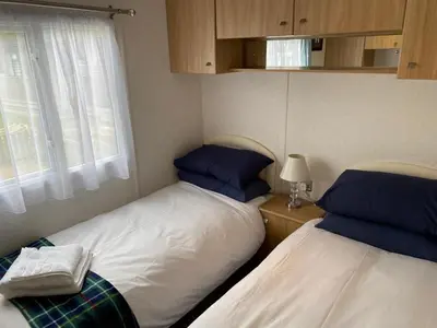 two twin beds in a room with a window at Rosie in Whithorn