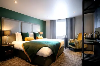 a hotel room with a large bed and a window at DeiRa Hotel & Apartments in Prestwick