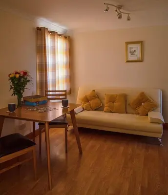 a living room with a couch and a table at No5 The Smiddy in Wigtown