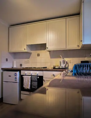 a kitchen with white cabinets and a counter top at No5 The Smiddy in Wigtown