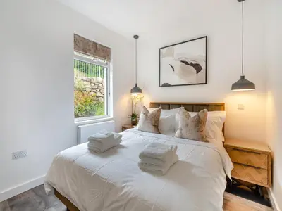 a bedroom with a white bed with towels on it at Berkeley in Kippford