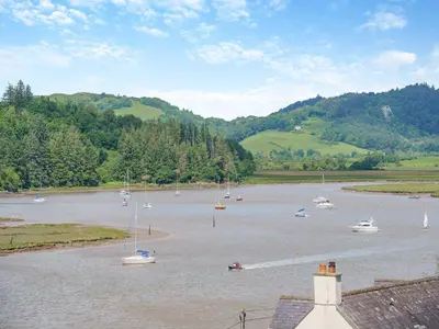 a group of boats floating on a river with trees at Berkeley in Kippford