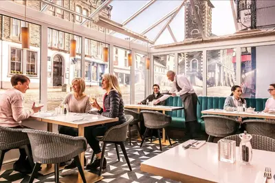 a group of people sitting at tables in a restaurant at Skiddaw Hotel in Keswick