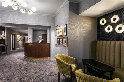a woman standing at a bar in a hotel lobby at Skiddaw Hotel in Keswick