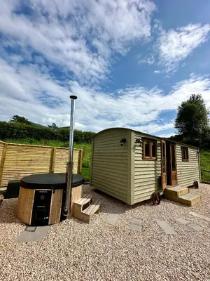 a small trailer sitting in a gravel yard at Lintmill Lodges - Thistle Shepherds Hut in Sorn