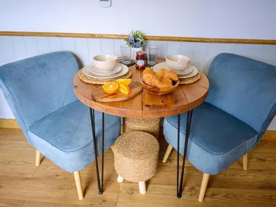 a table with blue chairs and a bowl of food on it at Lintmill Lodges - Bluebell Shepherds Hut in Sorn