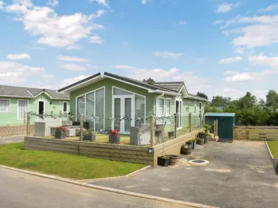 a house with a large deck in a driveway at Meadows Lodge - Uk46825 in Plumbland