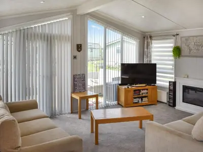 a living room with a flat screen tv and a couch at Meadows Lodge - Uk46825 in Plumbland