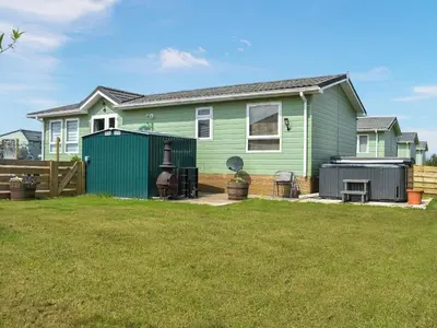 a green house with a fence in a yard at Meadows Lodge - Uk46825 in Plumbland