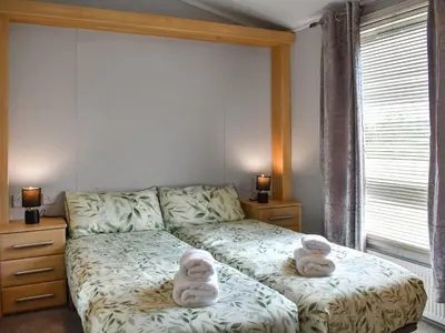 a bedroom with a bed with two stuffed animals on it at Meadows Lodge - Uk46825 in Plumbland