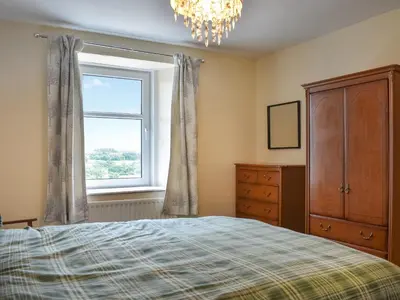 a bedroom with a bed and a dresser and a window at Uk46833 - Low Hollas Farmhouse in Threlkeld