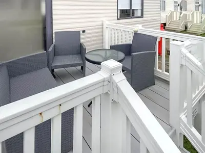 a porch with chairs and a table on a house at Merse Place 57- Uk46905 in Mainsriddle