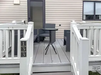 a porch with a table and a chair on a house at Merse Place 57- Uk46905 in Mainsriddle