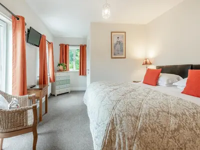 a bedroom with a large bed and a television at Stackgarth in Gilcrux