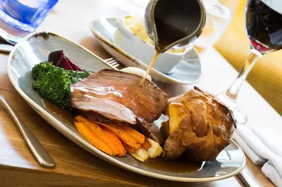 a plate of food with meat and vegetables on a table at Inn on the Square in Keswick