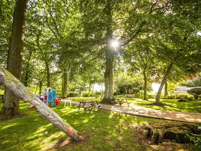 a park with a playground and picnic tables and trees at The Bothy in Ivegill