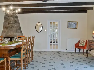 a dining room with a wooden table and chairs at Park Cottage in Gatehouse of Fleet