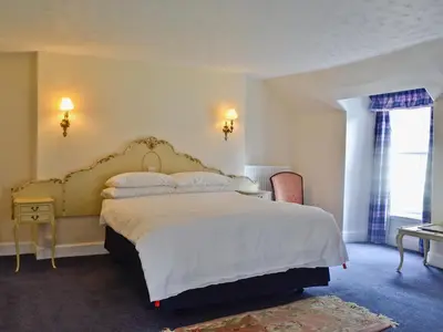 a bedroom with a large bed and a window at Park Cottage in Gatehouse of Fleet