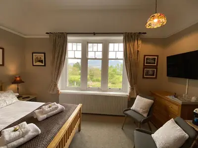 a bedroom with a bed and a large window at Lakeside Country Guest House in Bassenthwaite Lake