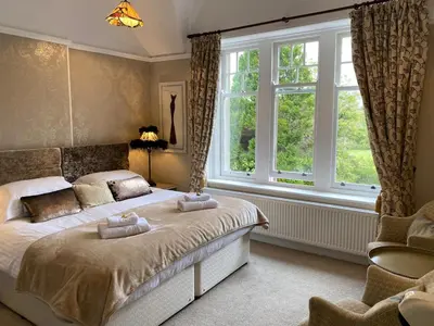 a bedroom with a bed and a large window at Lakeside Country Guest House in Bassenthwaite Lake