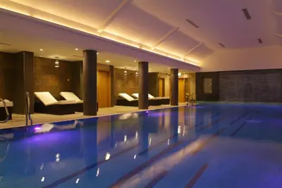 a swimming pool in a hotel with couches at Armathwaite Hall Hotel & Spa in Bassenthwaite