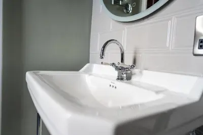 a white sink in a bathroom with a mirror at Armathwaite Hall Hotel & Spa in Bassenthwaite