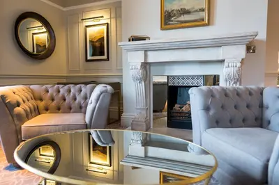 a living room with two couches and a fireplace at Armathwaite Hall Hotel & Spa in Bassenthwaite